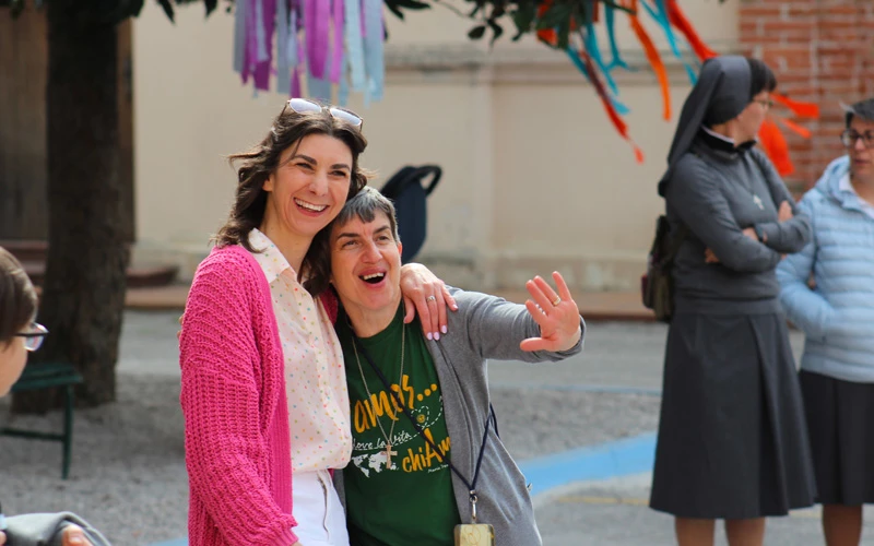 Due donne sorridenti che si abbracciano durante un momento di condivisione e festa